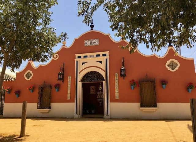 Fachada de la caseta El Bocao en el recinto ferial, de día: portada color teja con azulejos azules y el cartel «El Bocao»